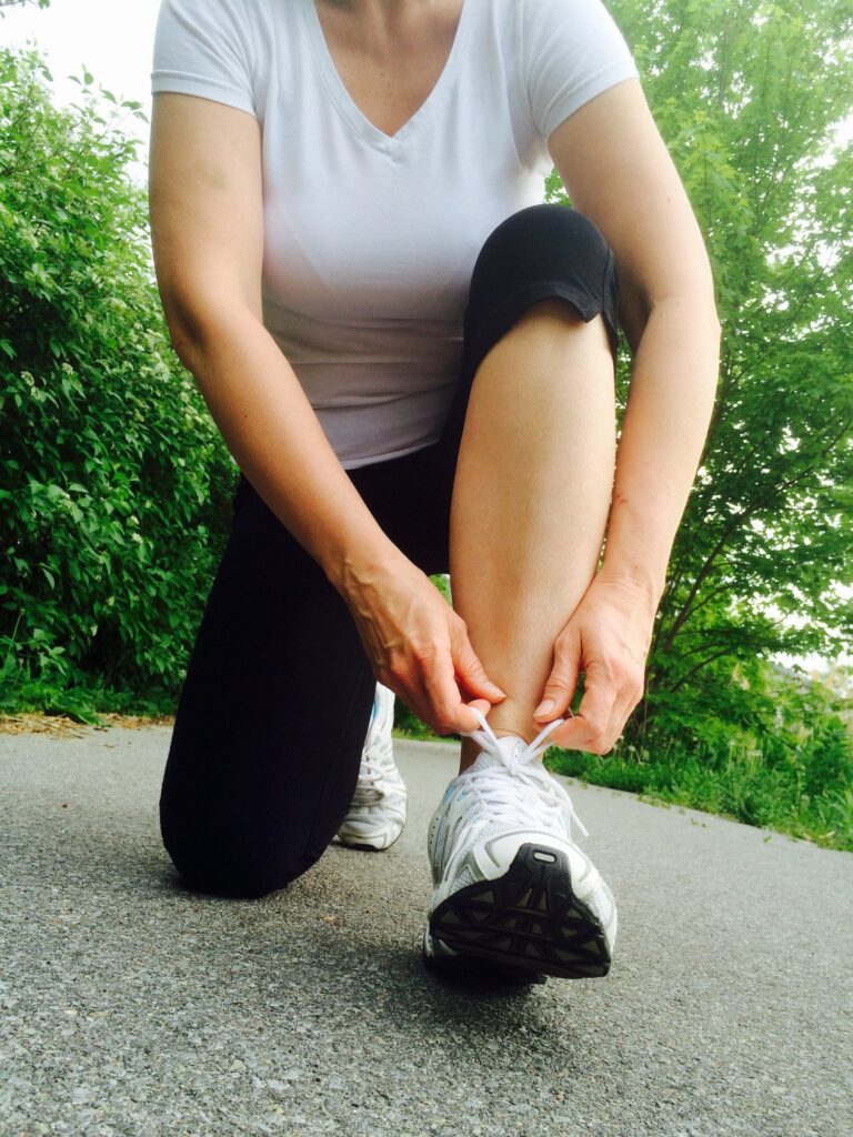 Woman preparing for daily running exercise tying running shoes, sports, health concept